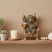 Bronze statue of a highland cow sitting in an armchair, holding a mug and wearing sunglasses and a chain.