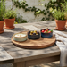 Outdoor setting with a wooden table, potted plants, and small bowls of food.